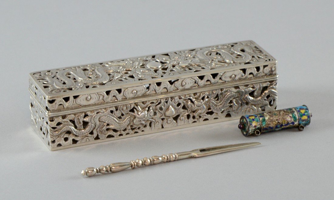 Chinese pierced silver box with hinged cover decorated: Chinese pierced silver box with hinged cover decorated with dragons amongst clouds and a flaming pearl, marks to base, 6" long, a two pronged fork and a miniature enamelled scroll holder,