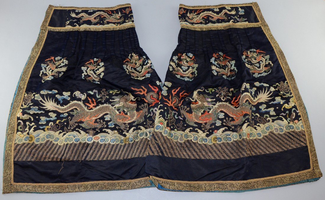 Two 19th century Chinese silk skirt panels, embroidered: Two 19th century Chinese silk skirt panels, embroidered with dragons in couched gilt thread the top section pleated and with wide embroidered band, 71 x 76 cm,