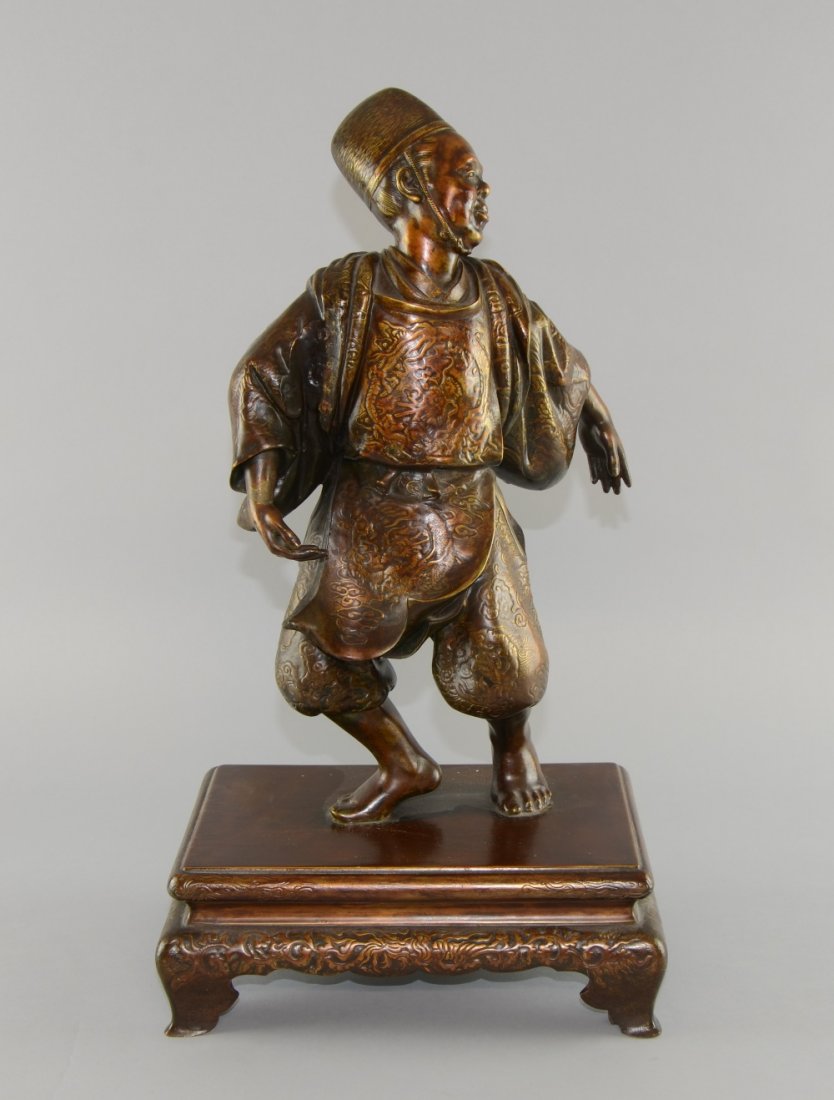 Japanese bronze figure of a man dancing on integral: Japanese bronze figure of a man dancing on integral ogee bracket base, 48cm high,