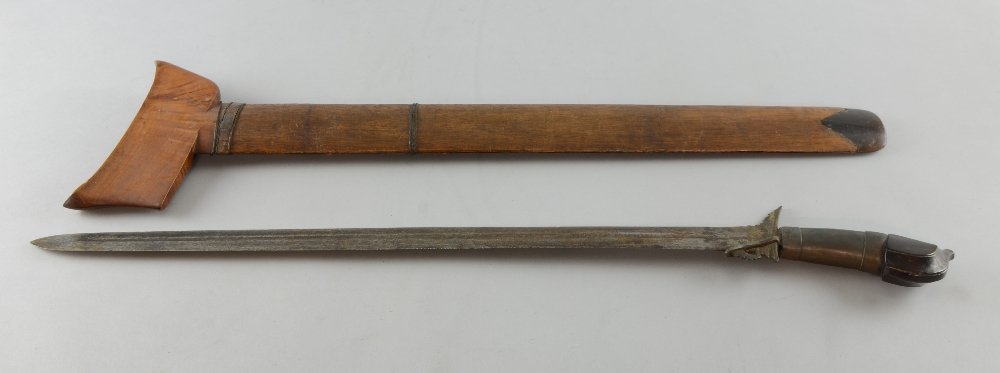 Malaysian sword with barbed steel blade, metal bound: Malaysian sword with barbed steel blade, metal bound and carved wooden handle, in carved wood and wire bound sheath, 70cm long, Blade worn and pitted. Blade repaired where it joins the handle. Sheath 