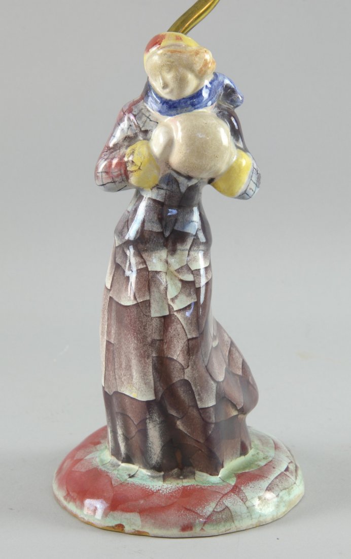 Michael Andersen and Son Pottery, Denmark, Art Deco: Michael Andersen and Son Pottery, Denmark, Art Deco table lamp modelled as a lady in a long coat decorated in cubist pattern, impressed and painted marks, paper label, total height 36cm.