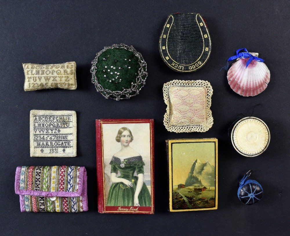 A Collection of needle cases and pin cushions, one with: A Collection of needle cases and pin cushions, one with picture of Jenny Lind, another with handpainted scene and a miniature sampler Harrogate 1831 (11)