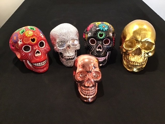 Collection of 5 Skulls Day of Dead: Largest 6.75 inches tallSmallest 4.5 inches tall One is a speaker for an iPhone ( pink rose colored skull)