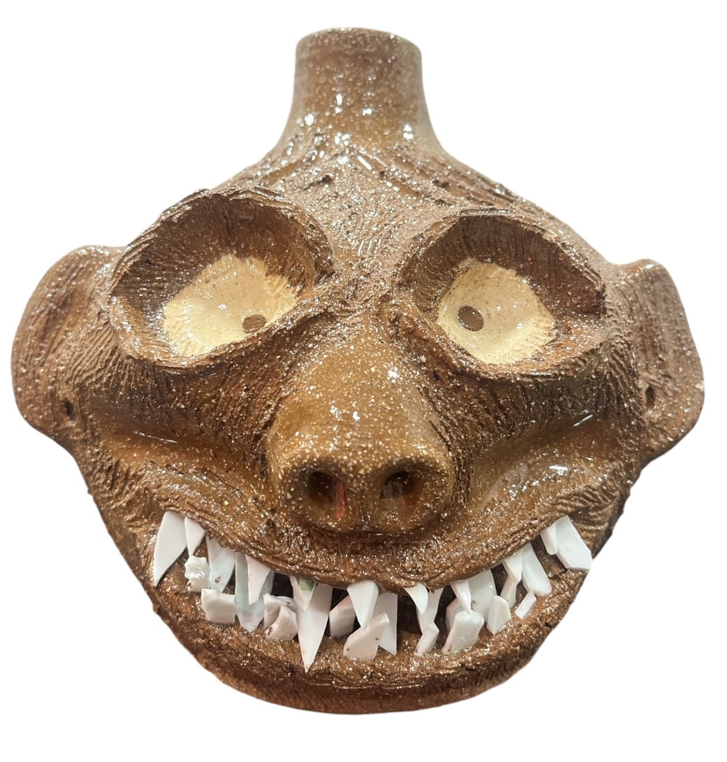 A Rare Signed DALE COSTNER Folk Art Face Jug: Signed and inscribed Dale Costner, Vale, NC on the bottom. 7" H x 7" W x 6.5" D. Unlike his other work, this piece features a large amount of sharp, carved teeth.