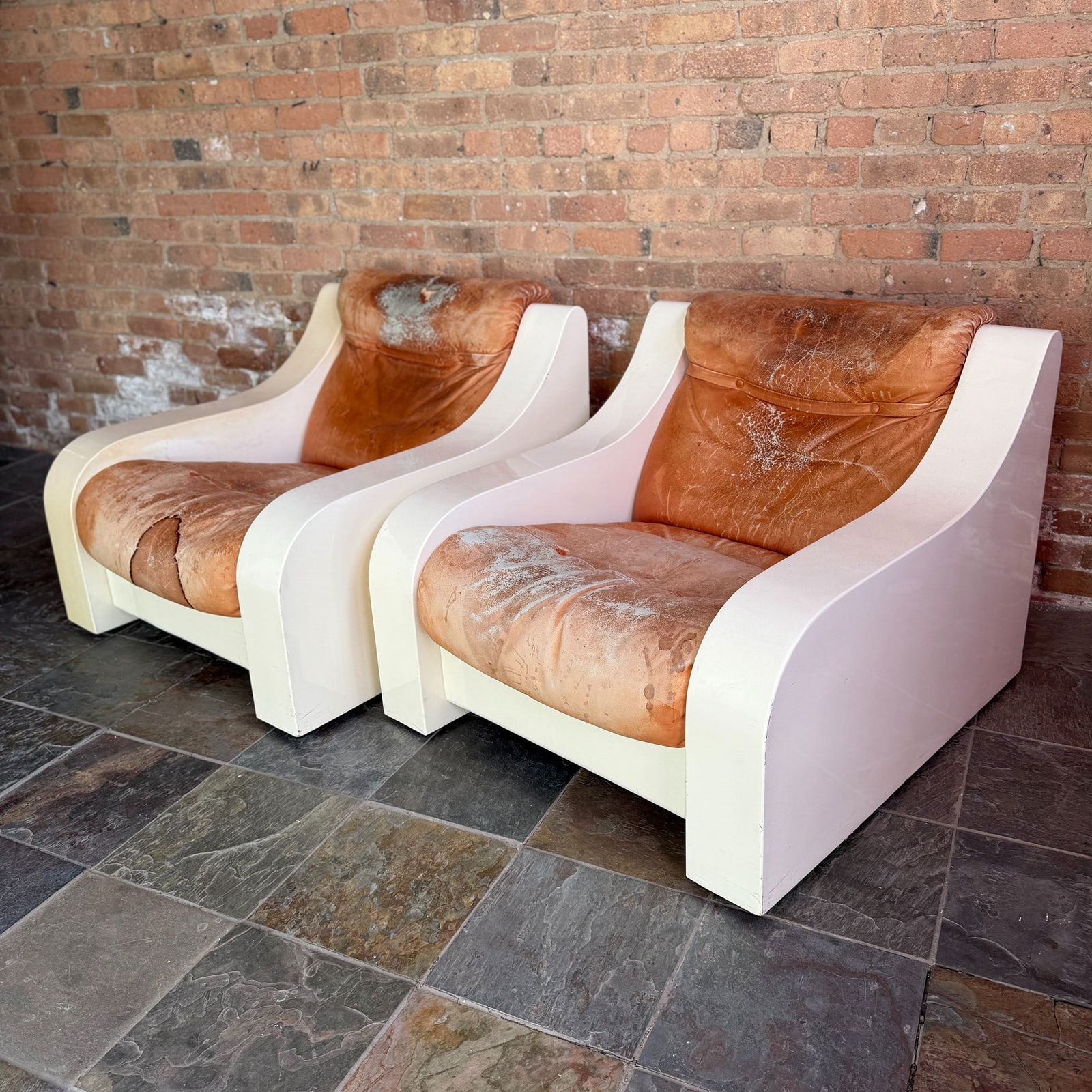 Italian Space Age Mid Century Lounge Chairs, Pair: In the style of Massimo Vignelli. Upholstered leather and fiberglass. Each char is on casters and rolls easily. Measures 28.5" H to back 17" H to seat x 33.75" W x 35.5" D, each.