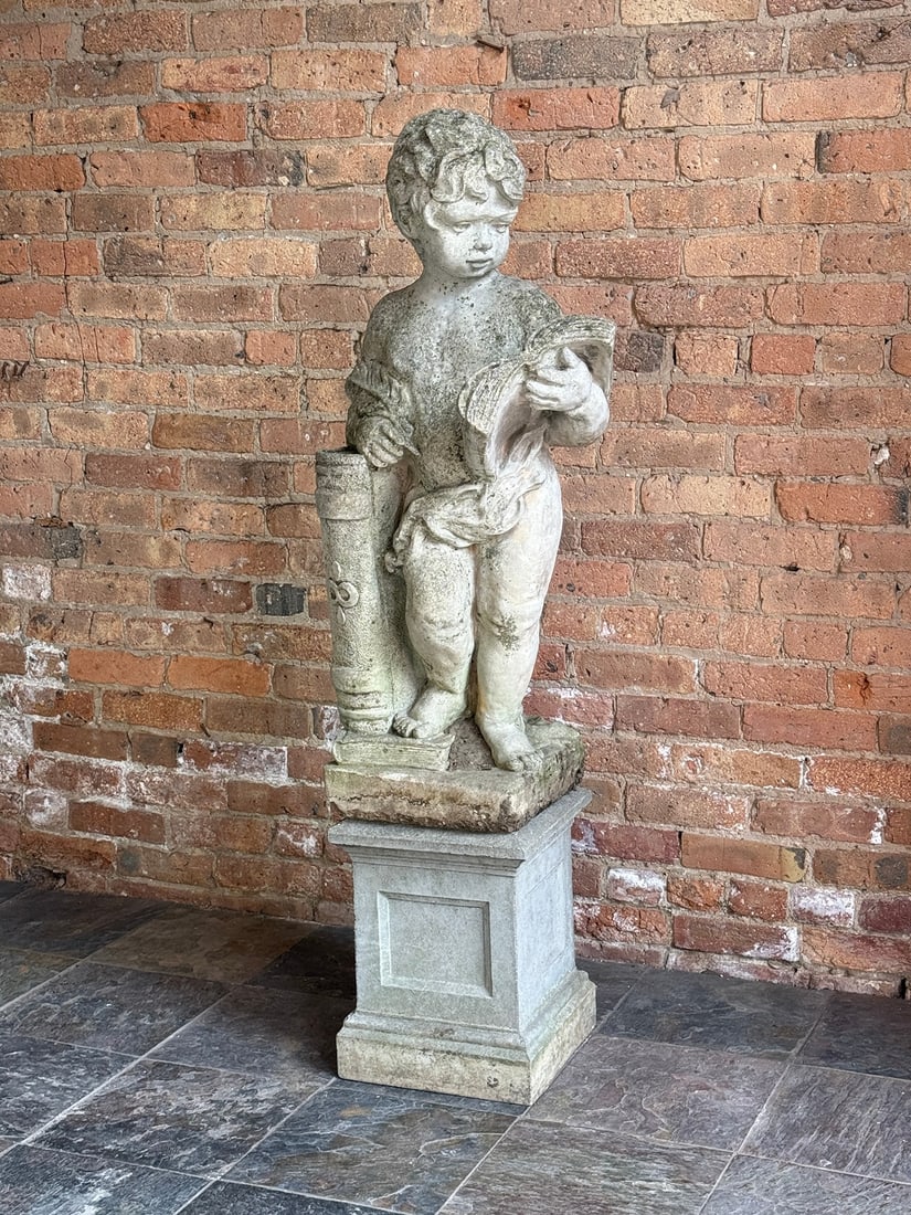 NINA STUDIO Quakertown, PA Cherub Reading Garden Statue: Cast stone, comes in two pieces. Measures 54" H overall x 15" to top of base x 39" H of statue x 19.5" W x 17" D. Base measures 12" W x 12" D. Stamped Nina Studio Quakertown, PA.