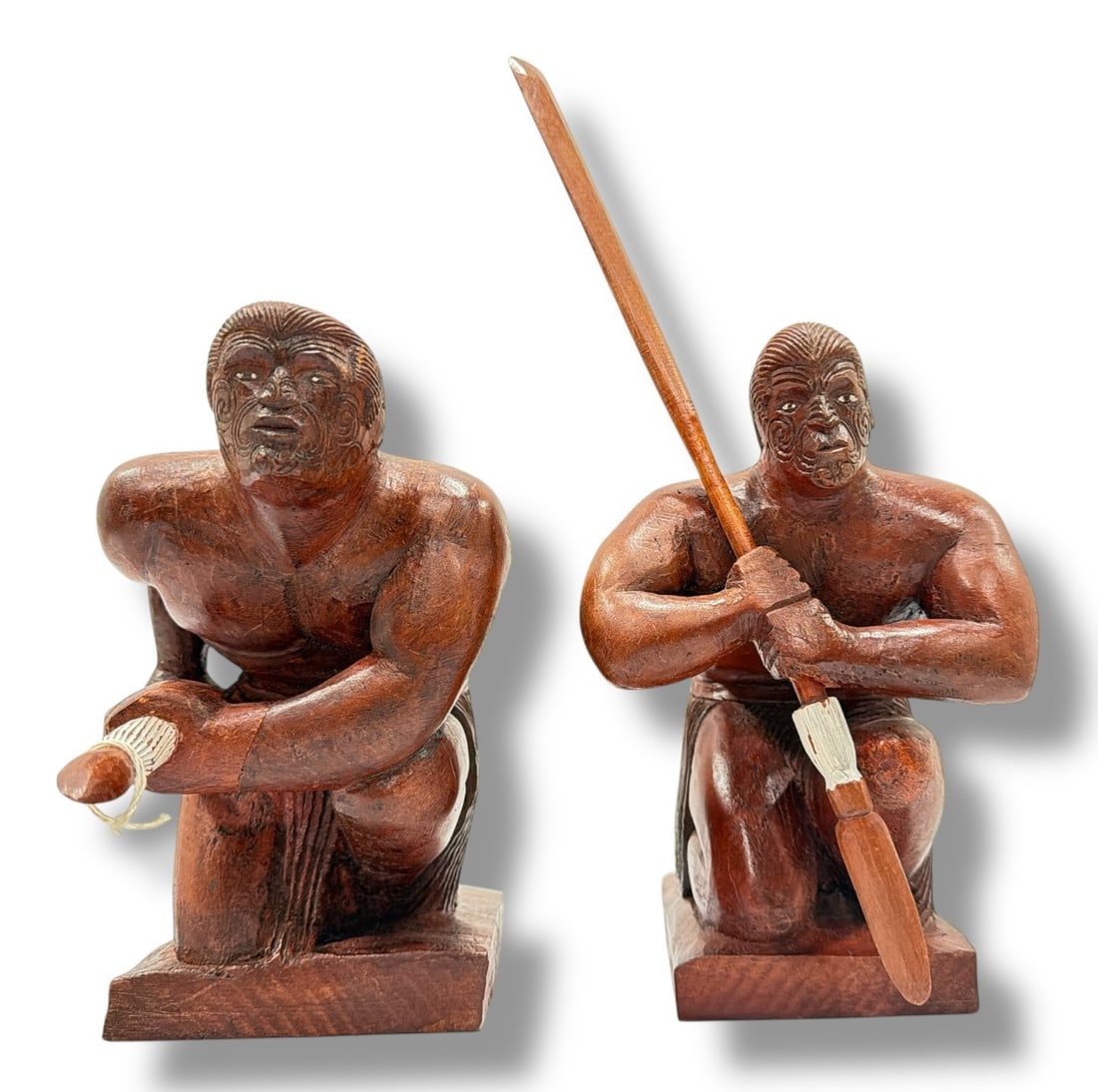 Two Carved Wood Maori Warrior Sculptures: Both measure approx. 8.5" H not including paddle x 6" W x 13" D including paddle.