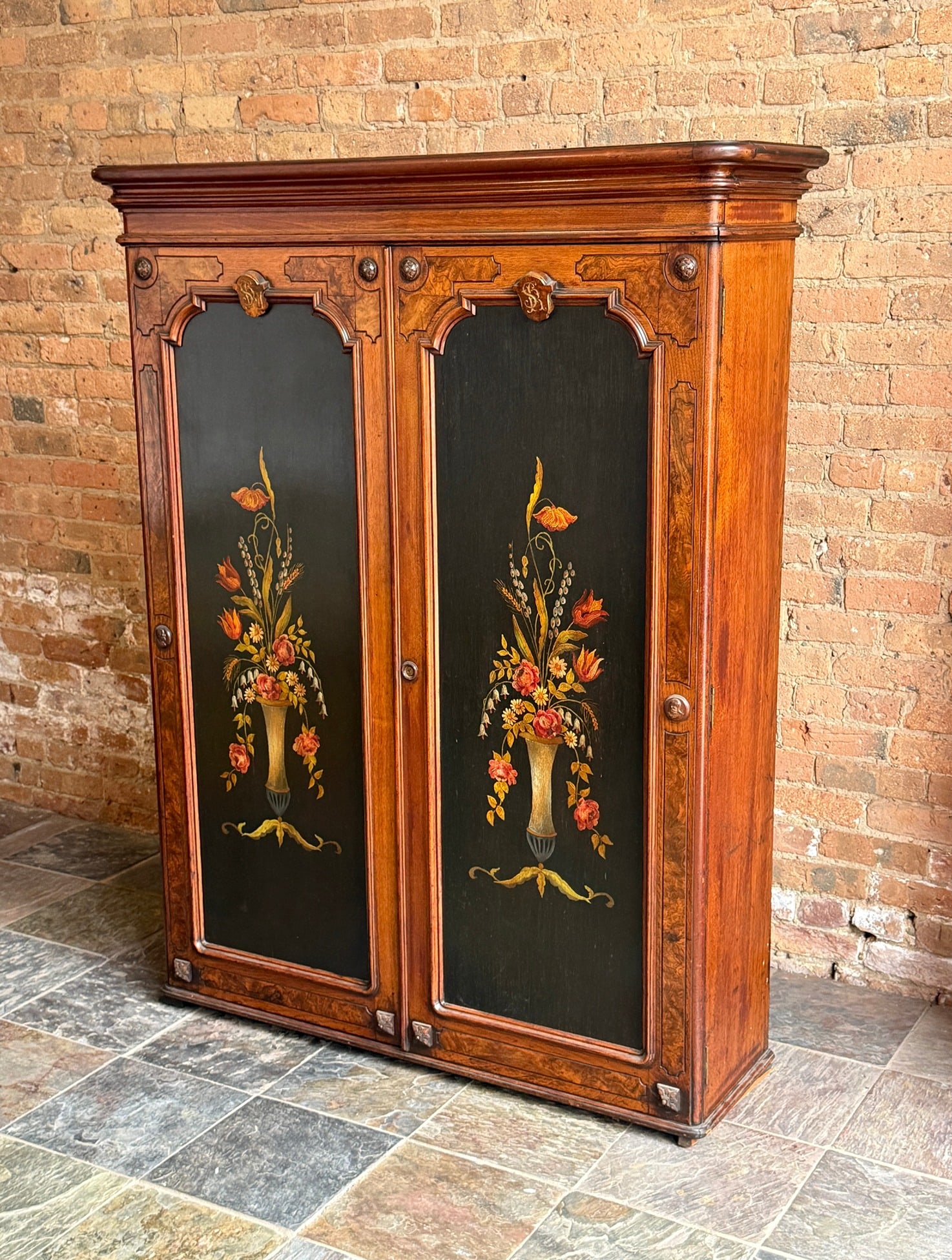 Antique Victorian Wardrobe: Measures 61.5" H x 47.75" W x 14.25" D. Hand painted inset door panels, burlwood inlay, carved face, rosettes, doors open to reveal 4 shelves and 3 drawers.