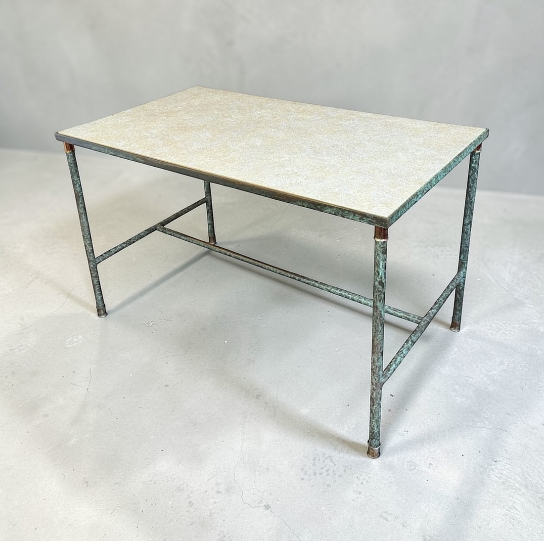 French Mid Century Patinated Copper Table: Patinated copper base with a faux stone top. Well constructed piece with the lines akin to Maison Jansen. Measures 30" H x 48" W x 28" D.