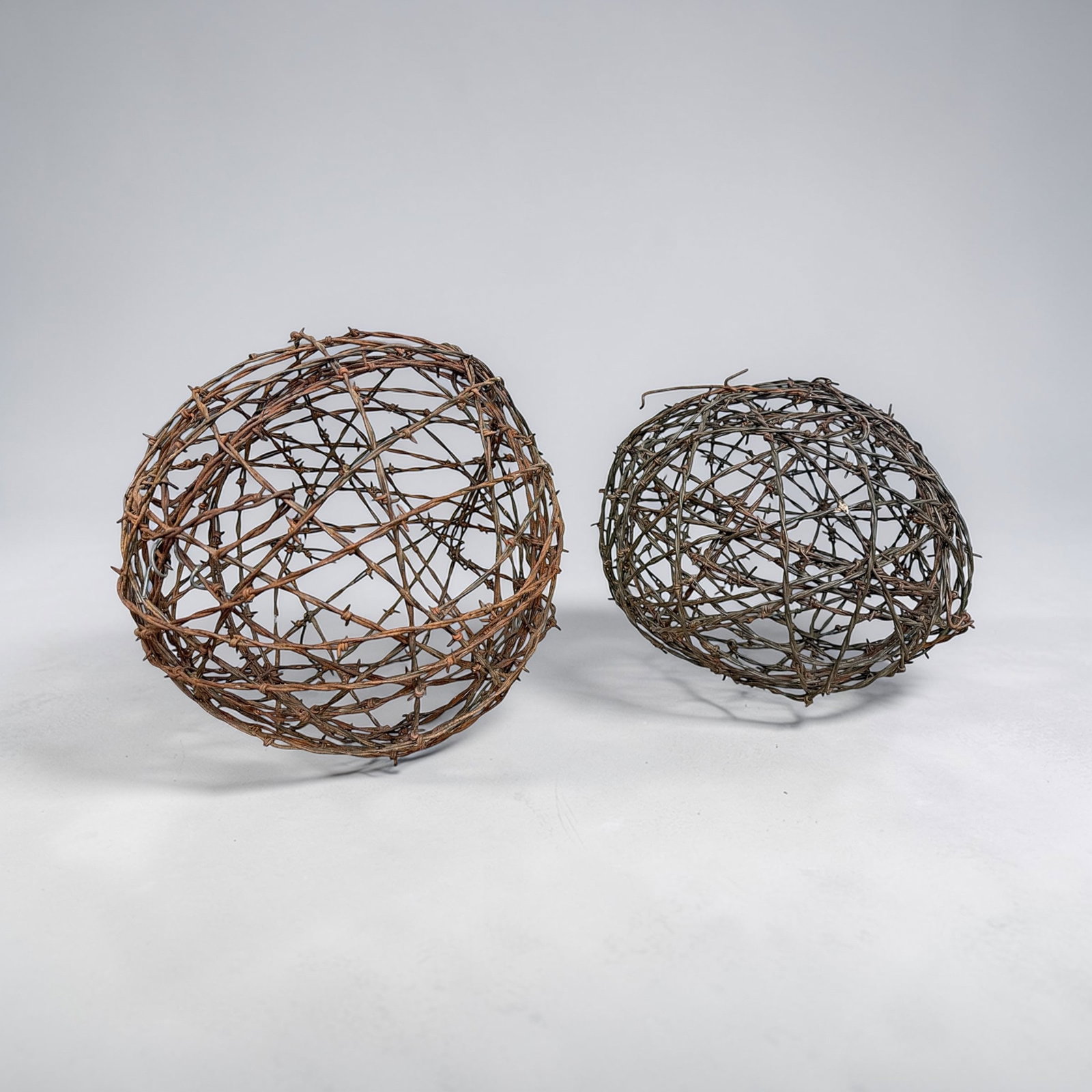 Two Folk Art Barb Wire Sphere Sculptures: Larger spike is 14" diameter and smaller is 12" diameter.