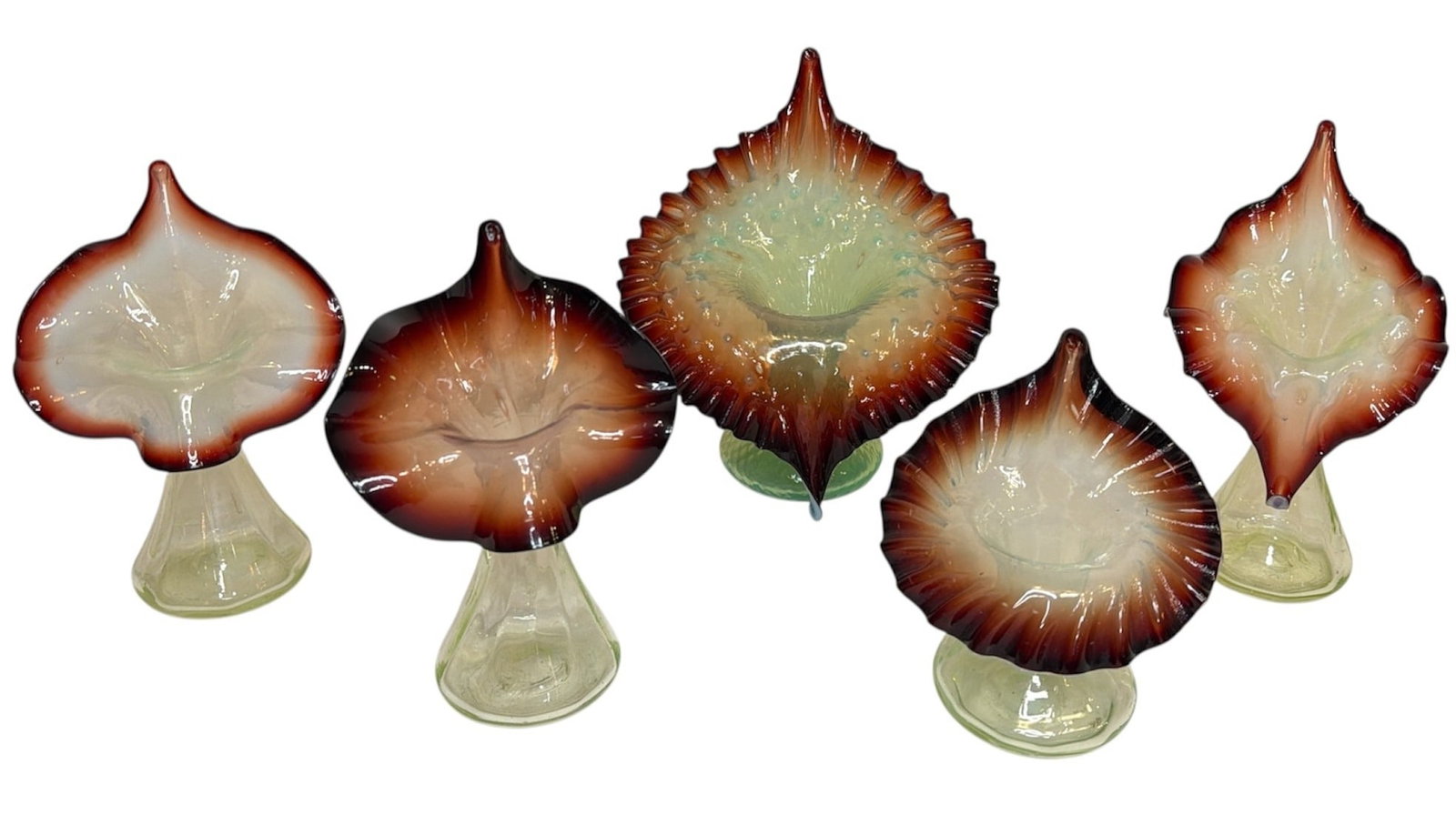 Collection of Uranium and Oxblood Art Glass Jack In The Pulpit Vases: Five victorian vaseline glass and oxblood glass jack-in-the-pulpit victorian vases. The largest measures 7.75" H x 7" W x 5" D, the smallest measures 5.25" H x 4.75" W x 3" D.