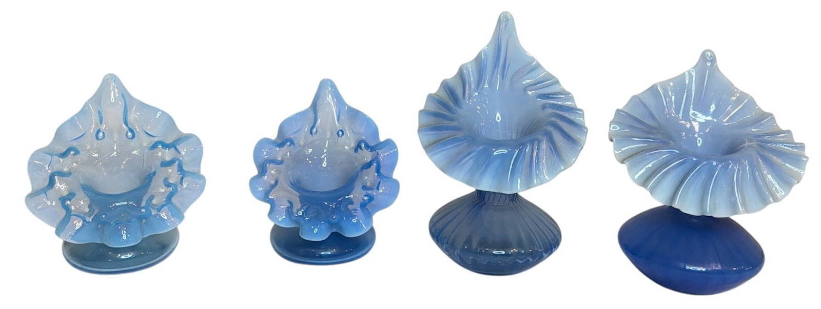 Four Victorian Blue Art Glass Jack In The Pulpit Vases: Includes four ruffled edge blue victorian art glass jack-in-the-pulpit vases. The largest measures 6.5" H x 4.25" W x 3.75" W, the smallest measures 4.25" H x 4" W x 3" D.
