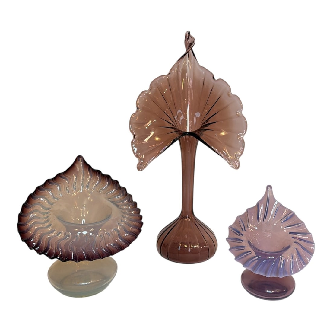 Three Purple and Uranium Glass Jack In The Pulpit Vases: Includes a purple edged uranium glass vase, a small lavender vase, and a large deep purple jack-in-the-pulpit vase. The largest measures 14" H x 7" W x 5" D.
