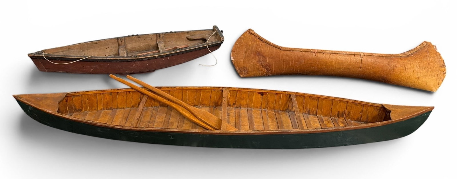 Three Vintage Canoe Models: Includes one marked "J.H. Keys, Maker, Newark, N.J." on the bottom, a birch bark canoe model, and a large canoe model with oars that measures 2.75" H x 27.5" W x 5" D.