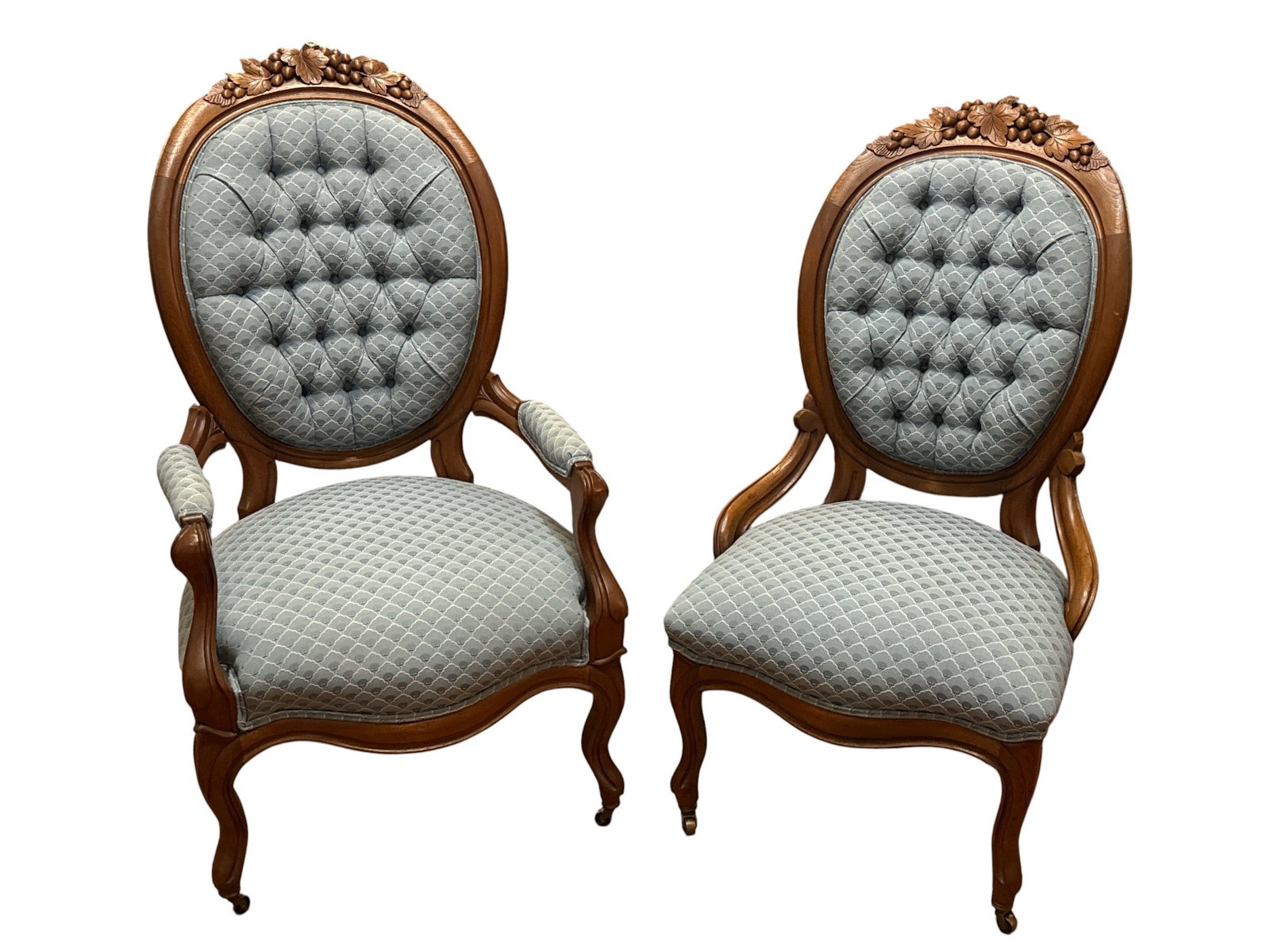 Late 19th C. Victorian Companion Parlor Chairs: His and her walnut companion parlor chairs with oval brocade backs featuring fruit and leaf motif carved wood, cabriole legs and casters The larger chair measures 46" H to the back x 18" H to the seat