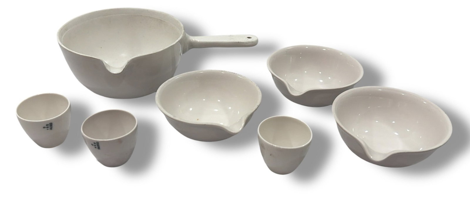 Early COORS USA Laboratory Measuring Cup Set: Largest piece measures 2" H x 6.5" W x 4" diameter, the medium measuring cups measure 1" H x 3" diameter, the smallest measure 1.25" H x 1.25" diameter.