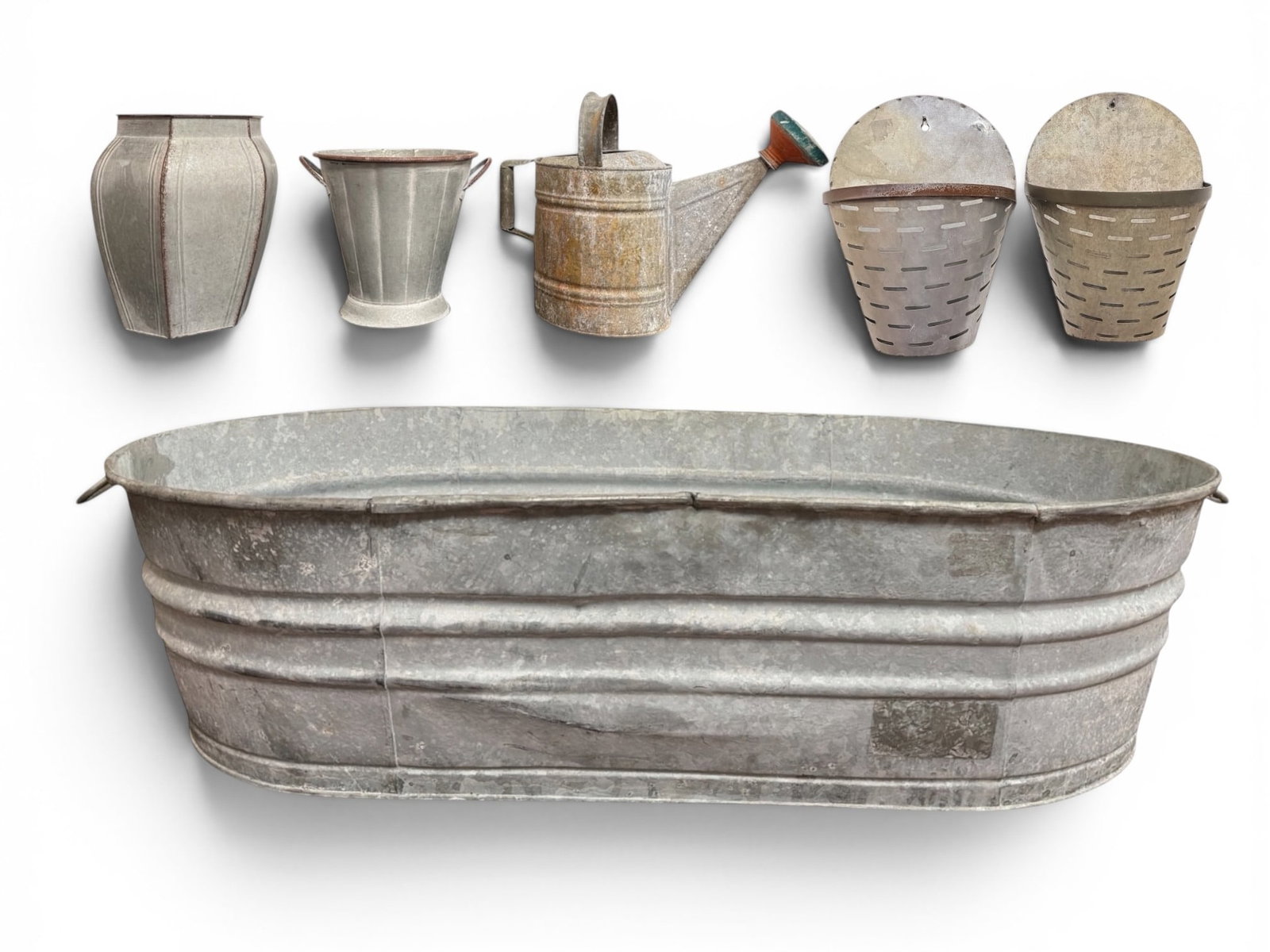 Collection of French Galvanized Metal Garden Articles: The large tub measures 11" H x 43.25" W x 23" D, both wall pockets are approx. 14" H x 10.5" W x 6" D. Lot also includes a French garden watering can, a handled vase, and a hexagonal vase.