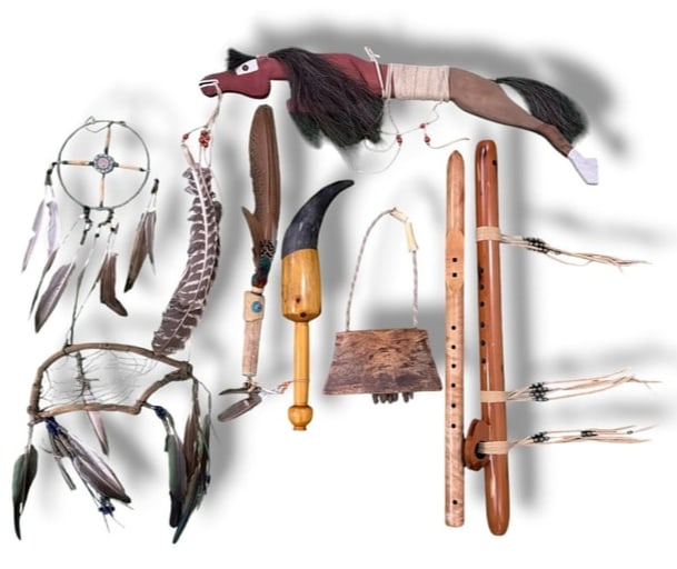 Collection of Native American Instruments and Dance Articles: Includes Native American flutes, cow bell, dance sticks, and dream catchers. The larger flute measures 25" x 3.5" x 2". The horse dance stick measures 9" H x 27" long x 1" D.