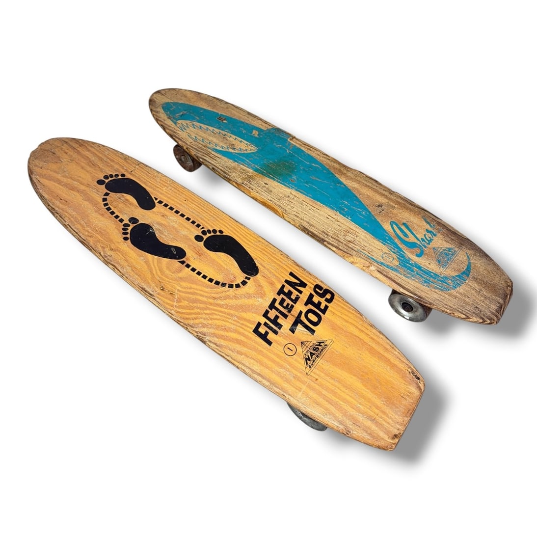 Two 1960's NASH Mfg. Surfboard Skateboards: Includes Nash "Fifteen Toes" Skateboard and Nash "Shark" Skateboard On the underside of the Fifteen Toes board, it reads "M. Bilby". Both measure approximately 3.5" H x 22" long x 5" W.