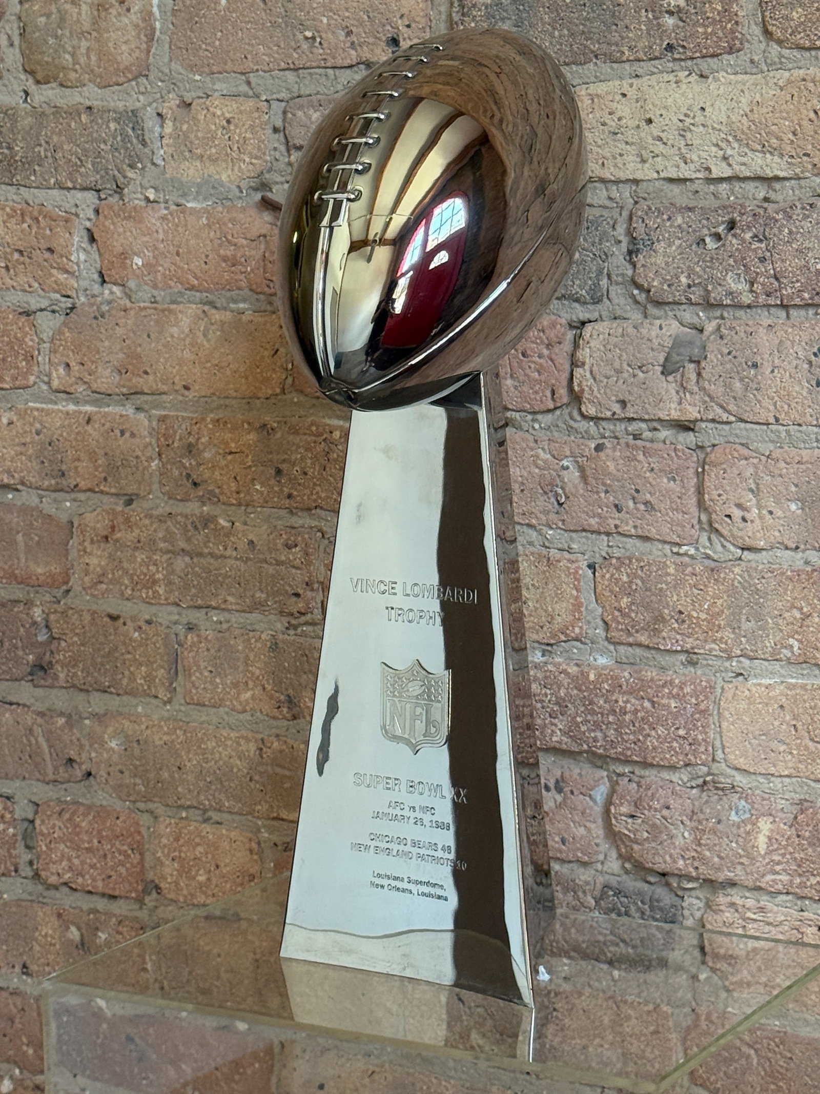 Super Bowl XX Vince Lombardi Trophy Replica, Chicago Bears vs. New England Patriots: Replica NFL Lombardi Trophy from 1985 Super Bowl XX. 21" H x 7" W x 7" D.