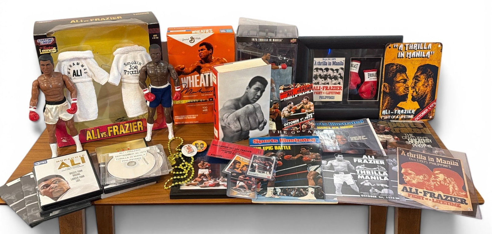 Collection MUHAMMAD ALI & JOE FRAZIER Boxing Memorabilia: Lot includes a 1998 Kenner Starting Lineup Timeless Legends Muhammad Ali and Joe Frazier with their boxing robs and original box that measures 13. 75" H x 12. 5" W x 5" D, Ali Book by Jonathan Eig, ph