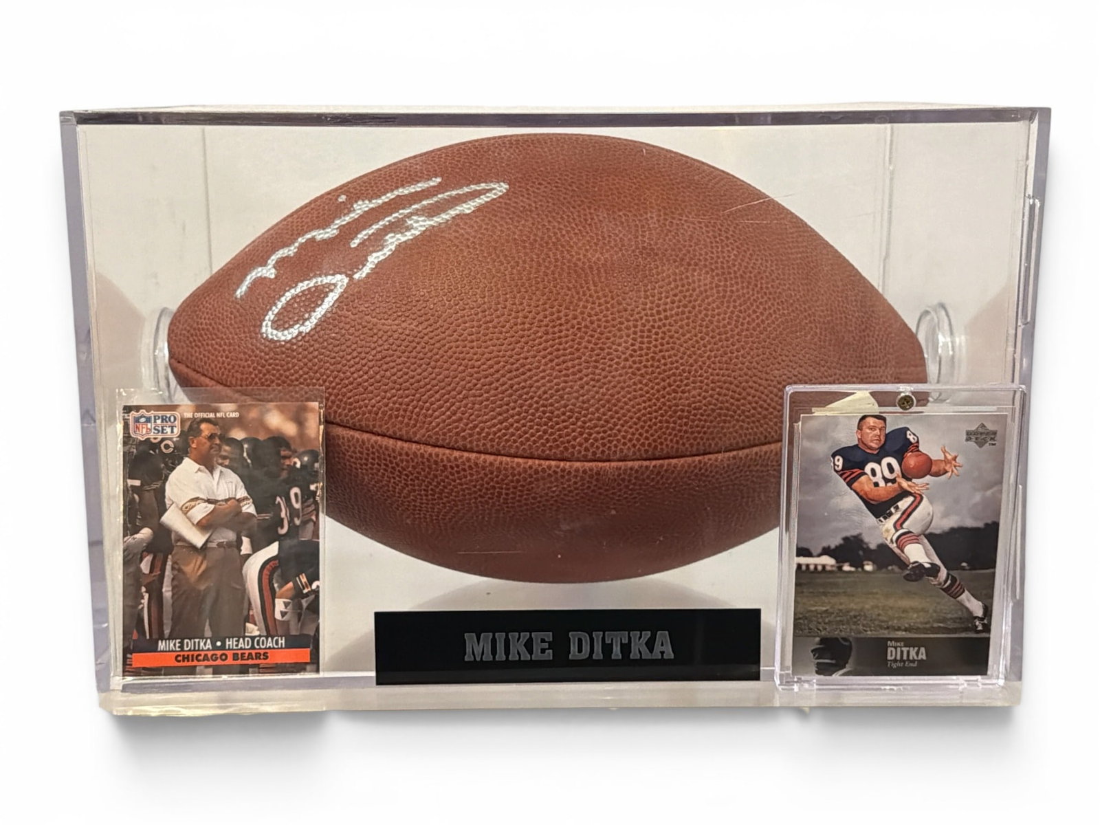 Autographed MIKE DITKA Chicago Bears Football: Includes a signed football by MIKE DITKA, a 1997 UPPER DECK Trading Card and a 1991 NFL Pro Set #108, Case measures 7. 5" H x 11. 75"x W x 7. 5" D.