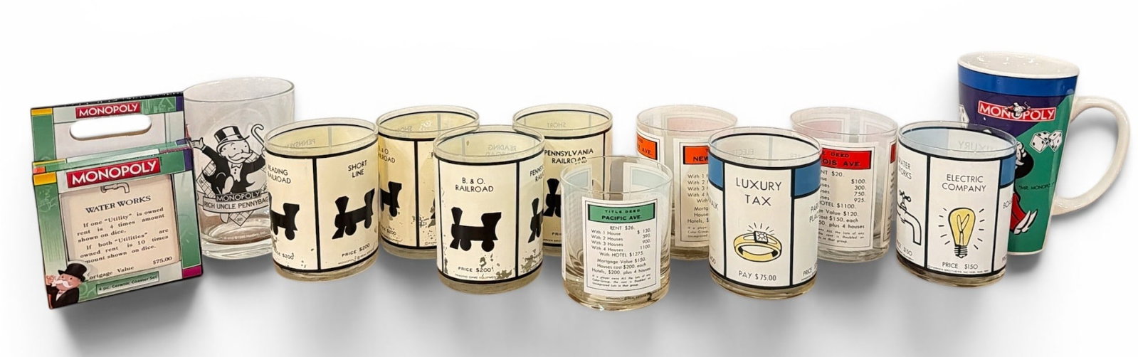 Collection MONOPOLY Barware Glasses and Coasters: Includes 1961 Parker Brothers lowball glasses that measure 4. 25" H x 3. 25" diameter, set of four coasters in original box, a 1996 McDonald's "Rich Uncle Pennybags" tumbler and more.