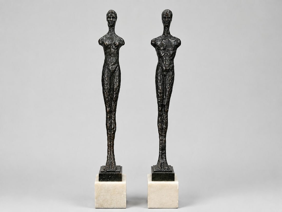 Man & Woman Bronze Figures in the style of GIACOMETTI: Marble and bronze. 20.75" H x 3" W x 3" D, each.