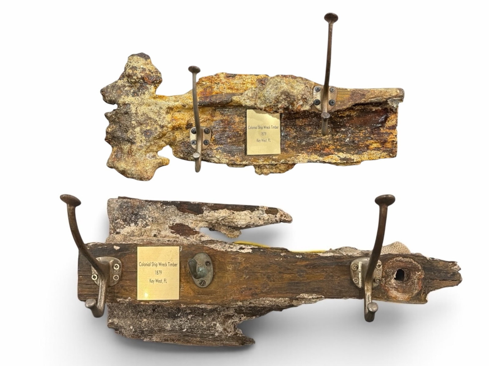 Two Colonial Salvage Shipwreck Coat Racks: The larger measures 12" H x 19" W x 8" D the smaller rack measures 8" H x 18" W x 10" D. Includes two coat racks fashioned from salvaged wood from a colonial shipwreck. The plaques read "Colonial