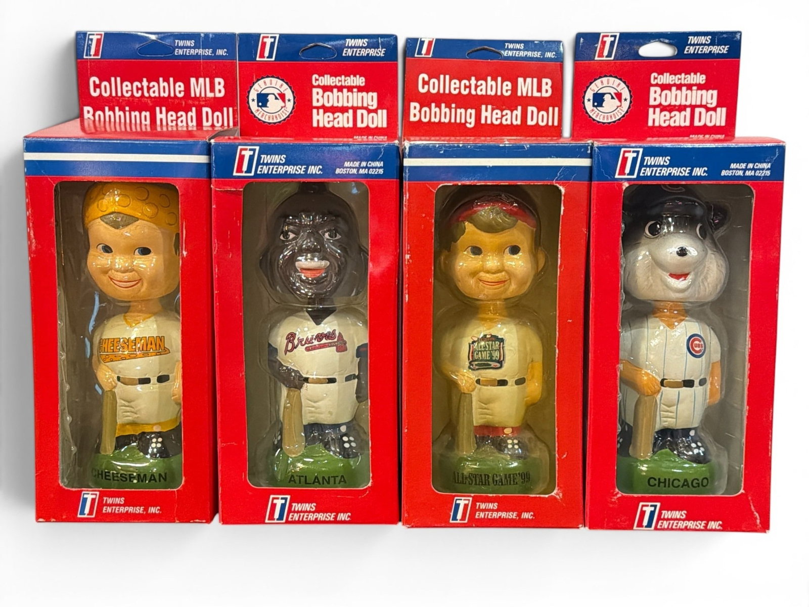 Four Vintage TWINS ENTERPRISE MLB Bobble Heads: Includes Four 1990's Twins Enterprise Baseball Bobbleheads such as Chicago Cubs, All Star Games 99', Cheesehead, and Atlanta Braves with their original boxes. Each box measures approx. 12" H x 4.25"