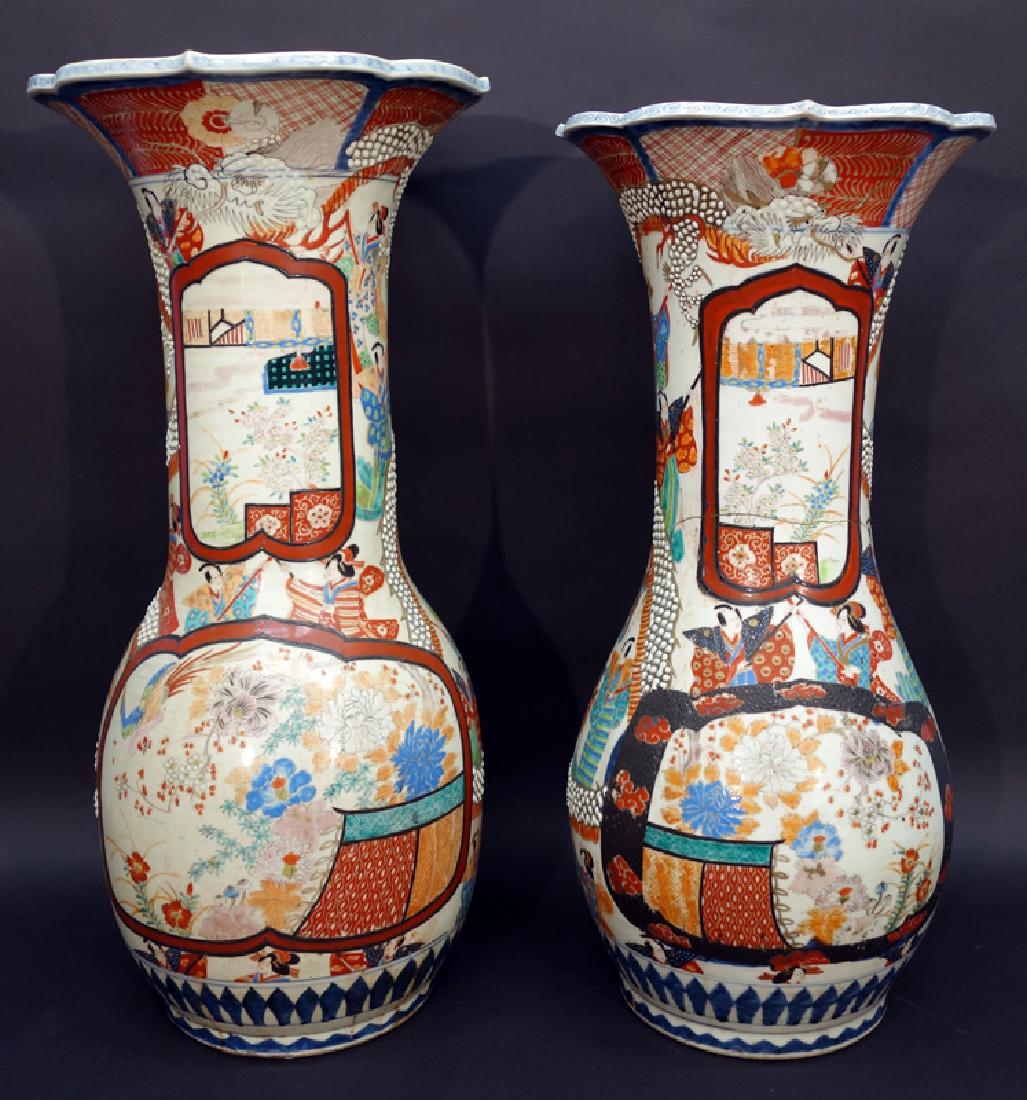 PAIR OF IMARI FLOOR VASES: Painted porcelain; shaped top edge; garden scenes with entwined dragons; slightly different heights; (1) vase top poorly repaired - glued, stapled and missing chip; hairline; H-30", P-G