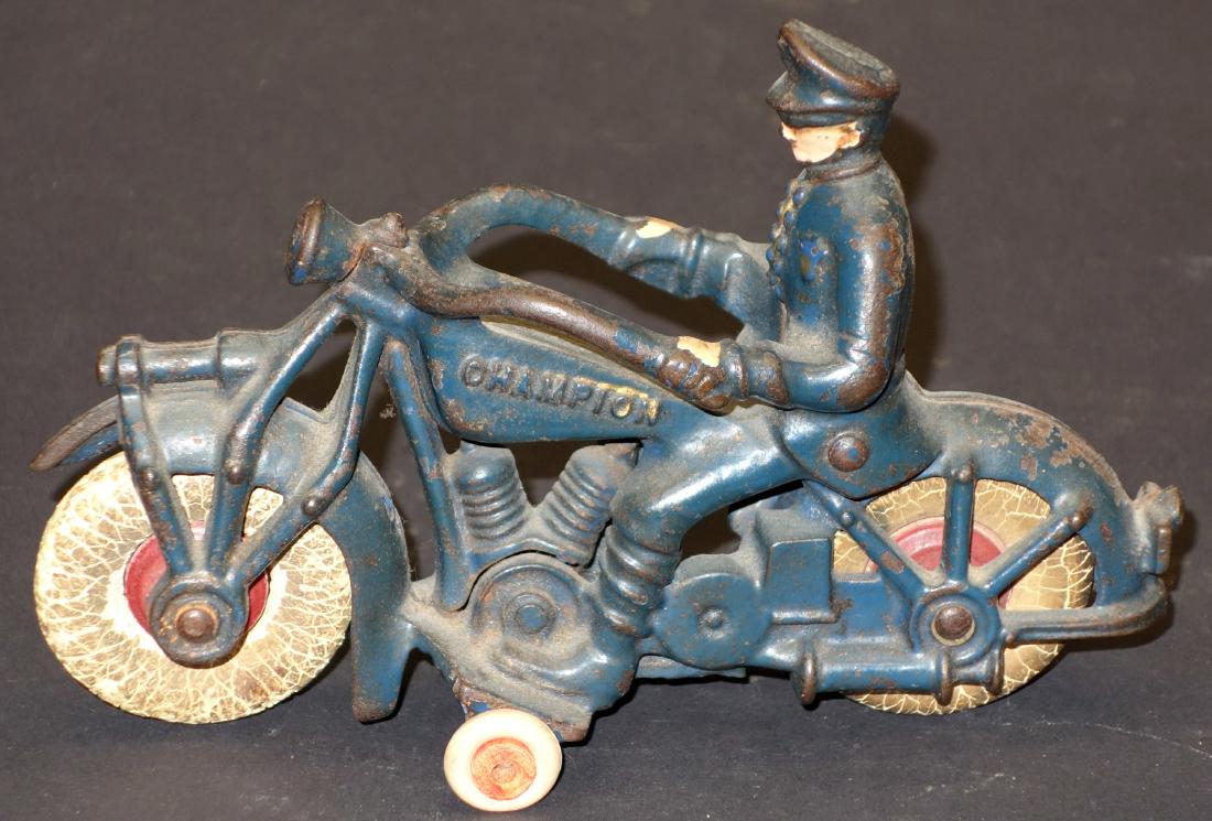CHAMPION POLICE MOTORCYCLE: painted cast iron; part of front fender missing; tire fatigue; paint loss; L-7", P-F