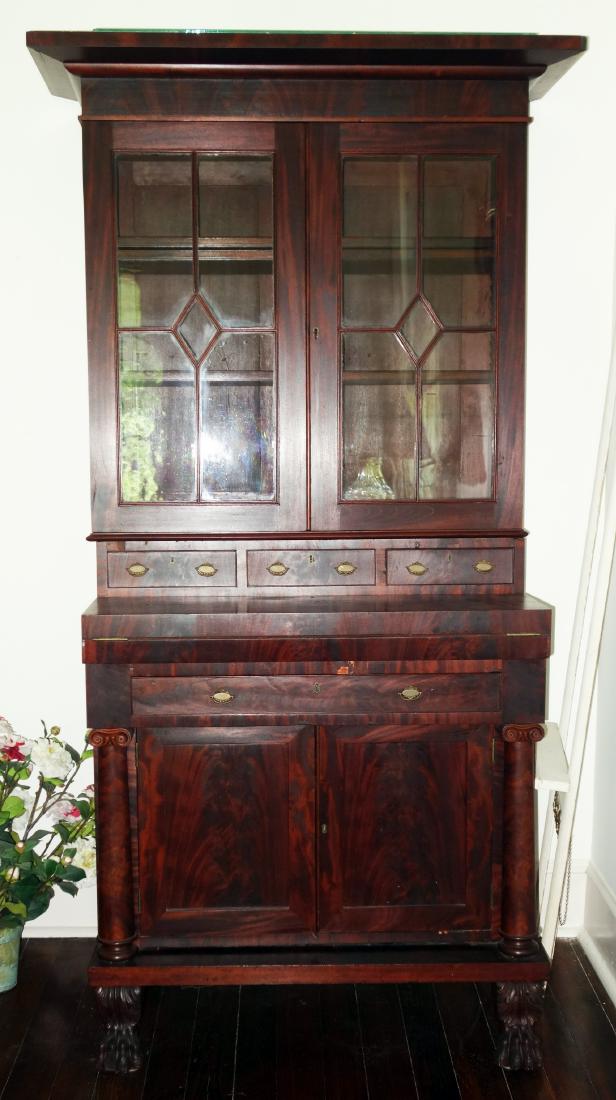 EMPIRE SECRETARY: Mahogany; (2) doors over (3) drawers; flip top desk over drawer and two doors; paw feet; slight checking in molded top; small pieces of veneer missing; H-84", W-37", G-VG