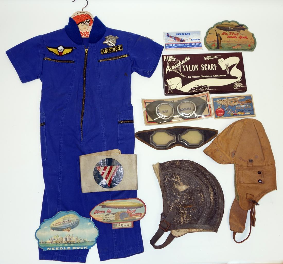 AERONAUTICAL CHILDRENS CLOTHES NEEDLE CASES: Includes: (5) needle cases, (2) head gear, (1) child's outfit, (3) child's goggles, (1) scarf, (1) arm band; wear; goggles- 10"; F-G