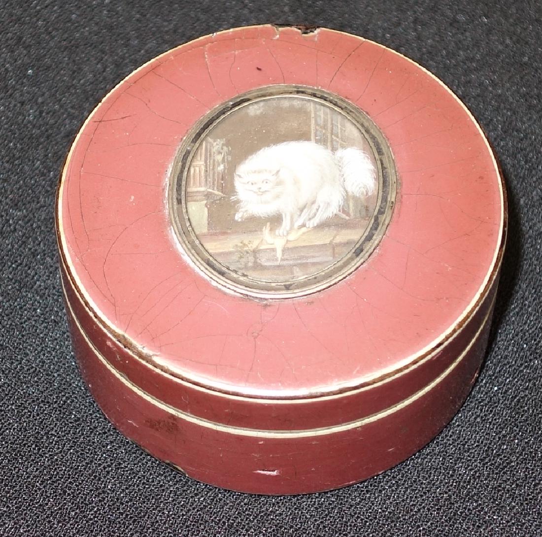 LACQUERWARE SNUFF BOX: Rouge painted with white trim; top inset with miniature painting of cat and bird; case chipped and crazed; Dia.-2 1/2", G