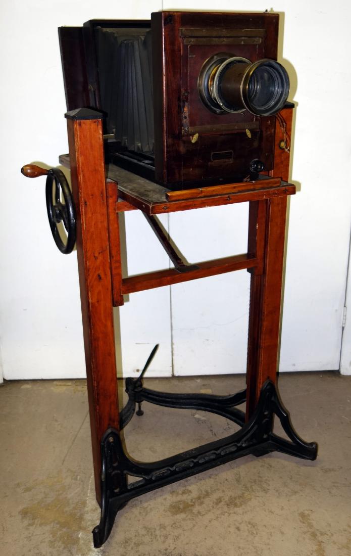 CENTURY 4 A STUDIO CAMERA: Wood frame-Folmar Graflex Corporation - Eastman Kodak; brass lens (F5 8x10); together with Century cast iron and wood elevating stand; normal wear; stand H-49", G-VG