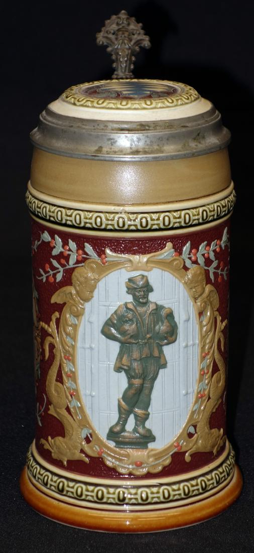 METTLACH STEIN "The Gooseman of Nuremberg" (1/2 L): Relief oval with dolphins and cherubs and man with goose; incised side panels and inlaid top; #2276; H- 8 1/2"; EX-VG