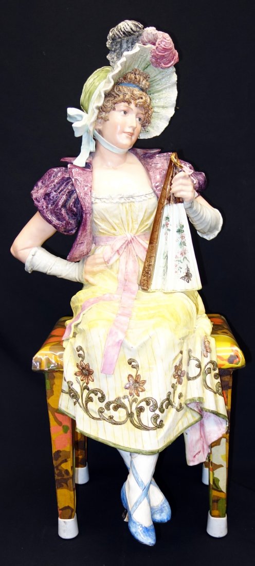 VICTORIAN SEATED LADY: Ceramic; unmarked; chair not original; appears to be repaired across lap; feet are repaired with large chip; minor chips on dress edge and (1) small chip on pink bow; needs cleaning; H-32"-figure only