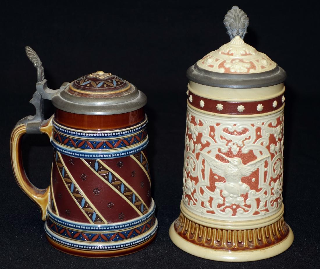 METTLACH STEINS: (2) with inlay lids; (1) relief geometric decoration with brids; 3/10 L; #2232 (2) incised geometic bands with relief beading; #1939; H- 6-7"; EX-VG