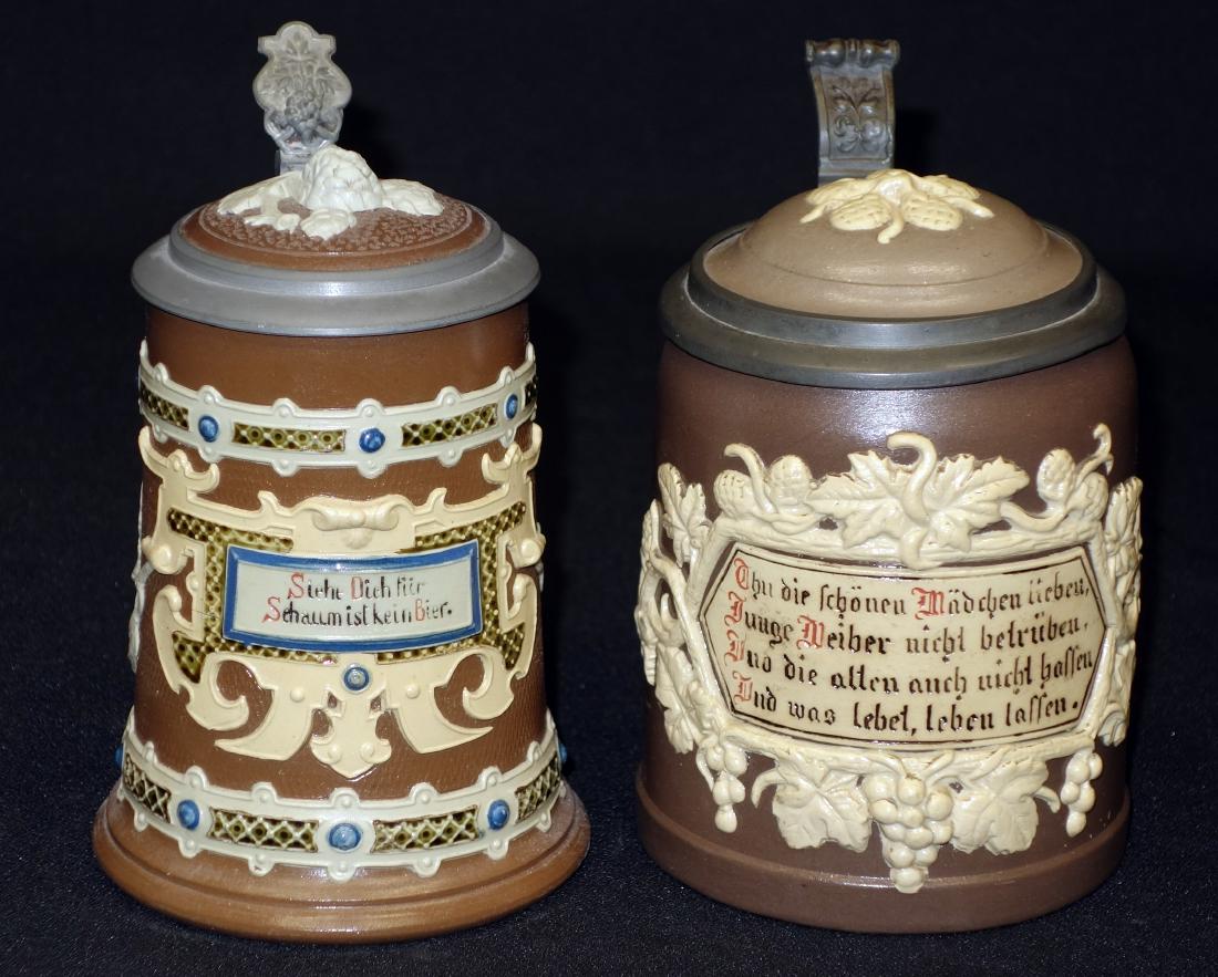 METTLACH STEINS: (2) inlay lids; floral relief decoration and verses; (1) 1/2 L #1180; (1) 1/4 L; #1745; H- 6+/- "; EX-VG