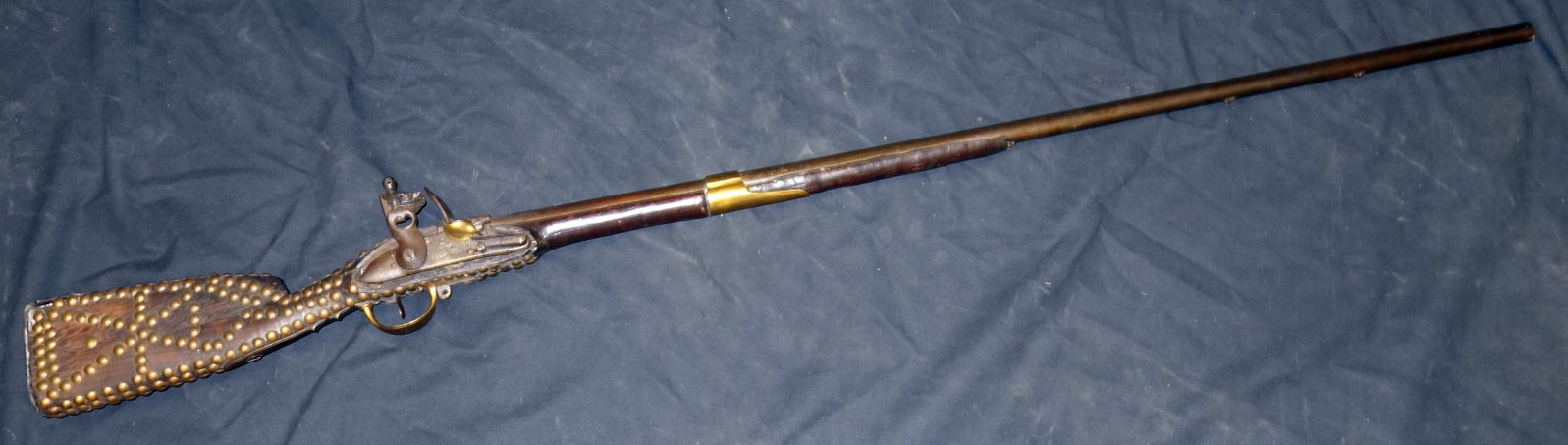 EARLY FLINTLOCK LONG GUN: Wood, brass, wrought iron, with brass tack decoration; lock box looks replaced and smaller than opening; marked Paris; pitting and wear; L-59", F