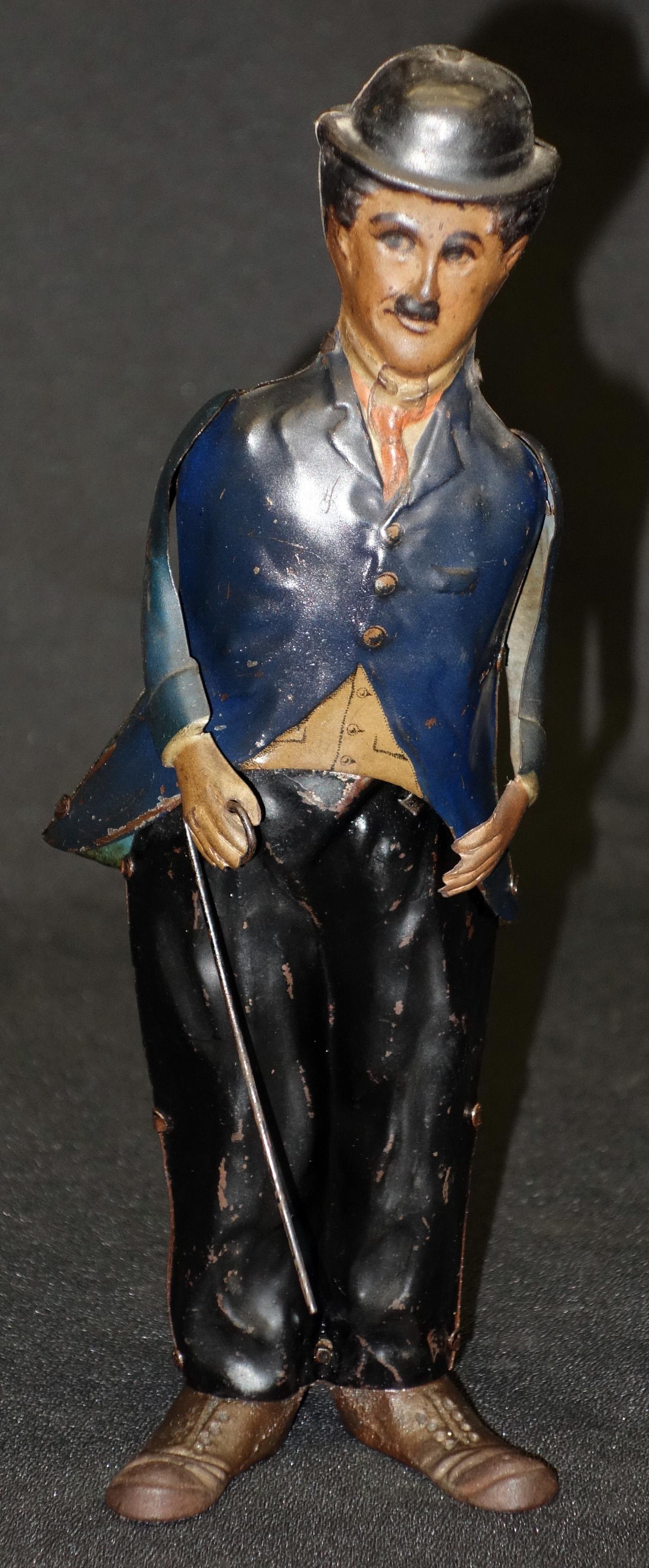 CHARLIE CHAPLIN TOY: German litho tin with cast iron feet; mechanical; works but needs lubricant; needs cleaning; normal wear; H-8 1/2", G