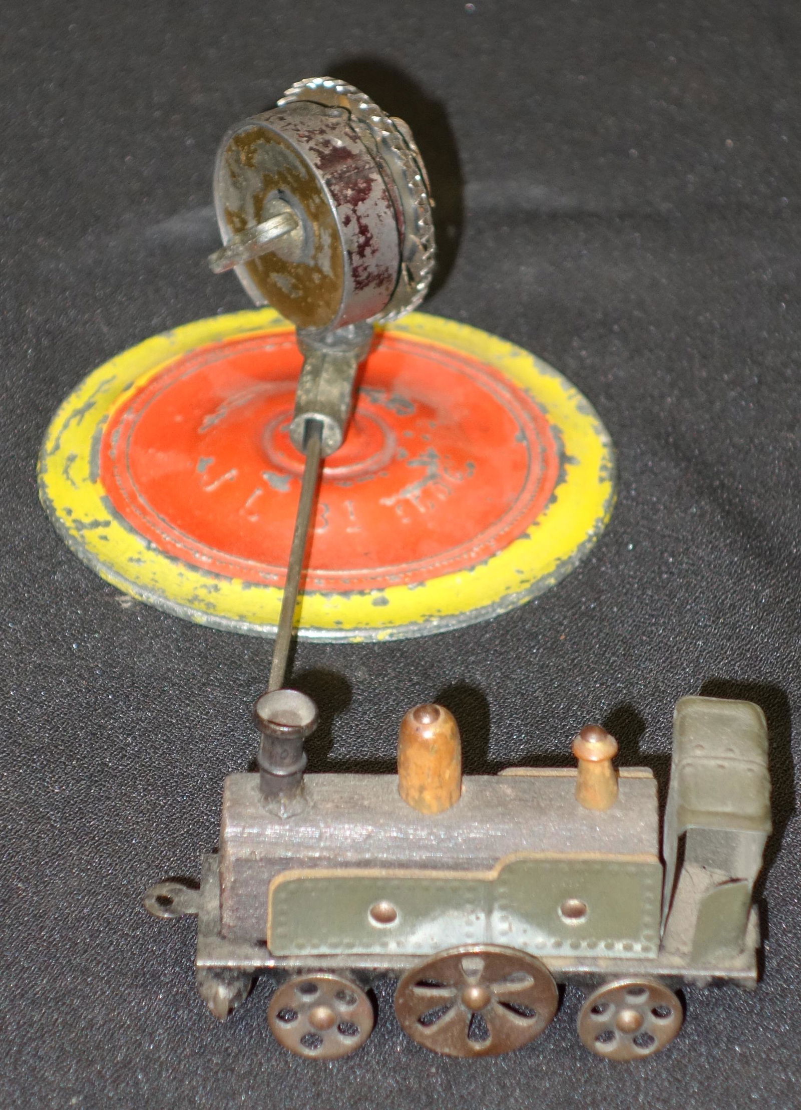 J. L. TRAIN ROUNDABOUT: French; painted pot metal base, tin and wood; mechanical; working; wear; Dia.-7 1/2", G