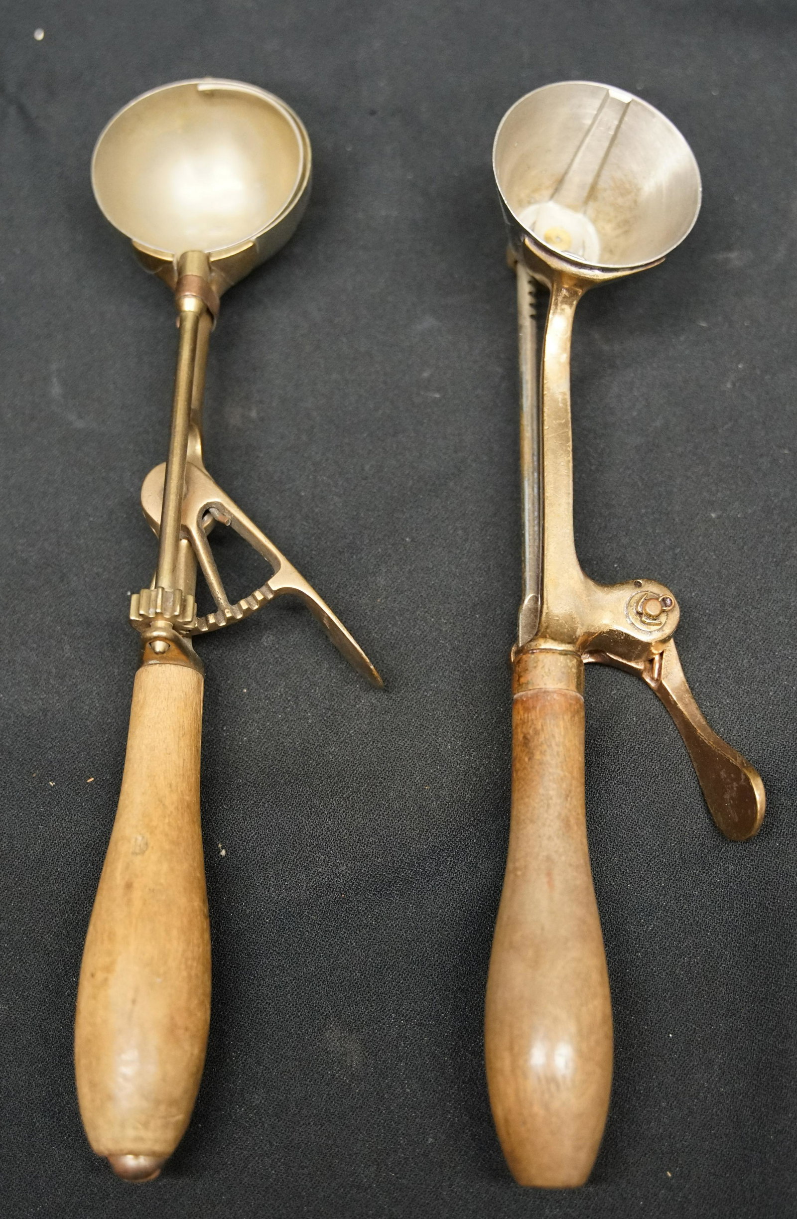 GILCHRIST ICE CREAM SCOOPS (2): Polished brass with wood handle; (1) #31, round bowl; (1) #33, conical bowl; L-10"; G-VG