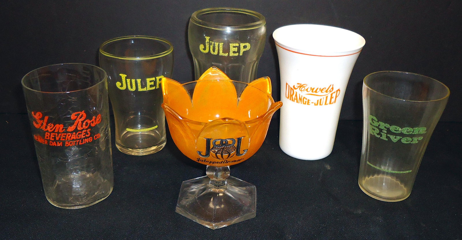 SODA FOUNTAIN GLASSES (6): Painted and etched letters; (1) figural Julep orange sherbert; (1) milk glass Howel's Orange-Julep; (2) Julep (different); (1) Green River; (1) Glen Rose; normal wear; H-4"-5"; G-VG