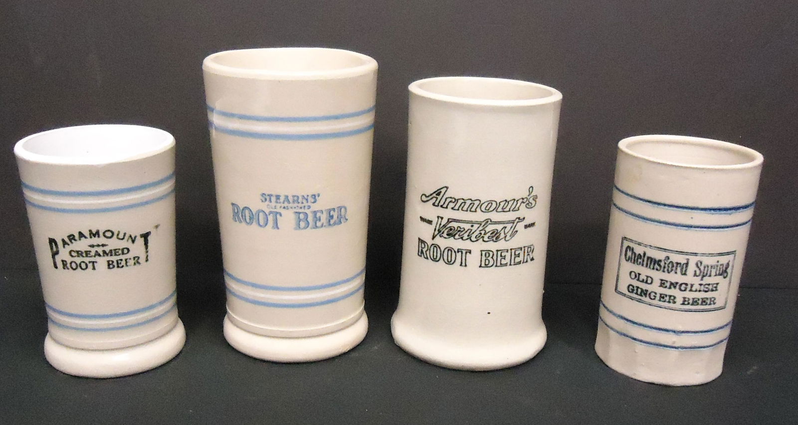 ROOT BEER MUGS (4): Ceramic, (1) Paramount; (1) Chelmsford; (1) Stearns; (1) Armour's; slight crazing, mold flaws; H-4 3/4"-6 1/2"; G-VG