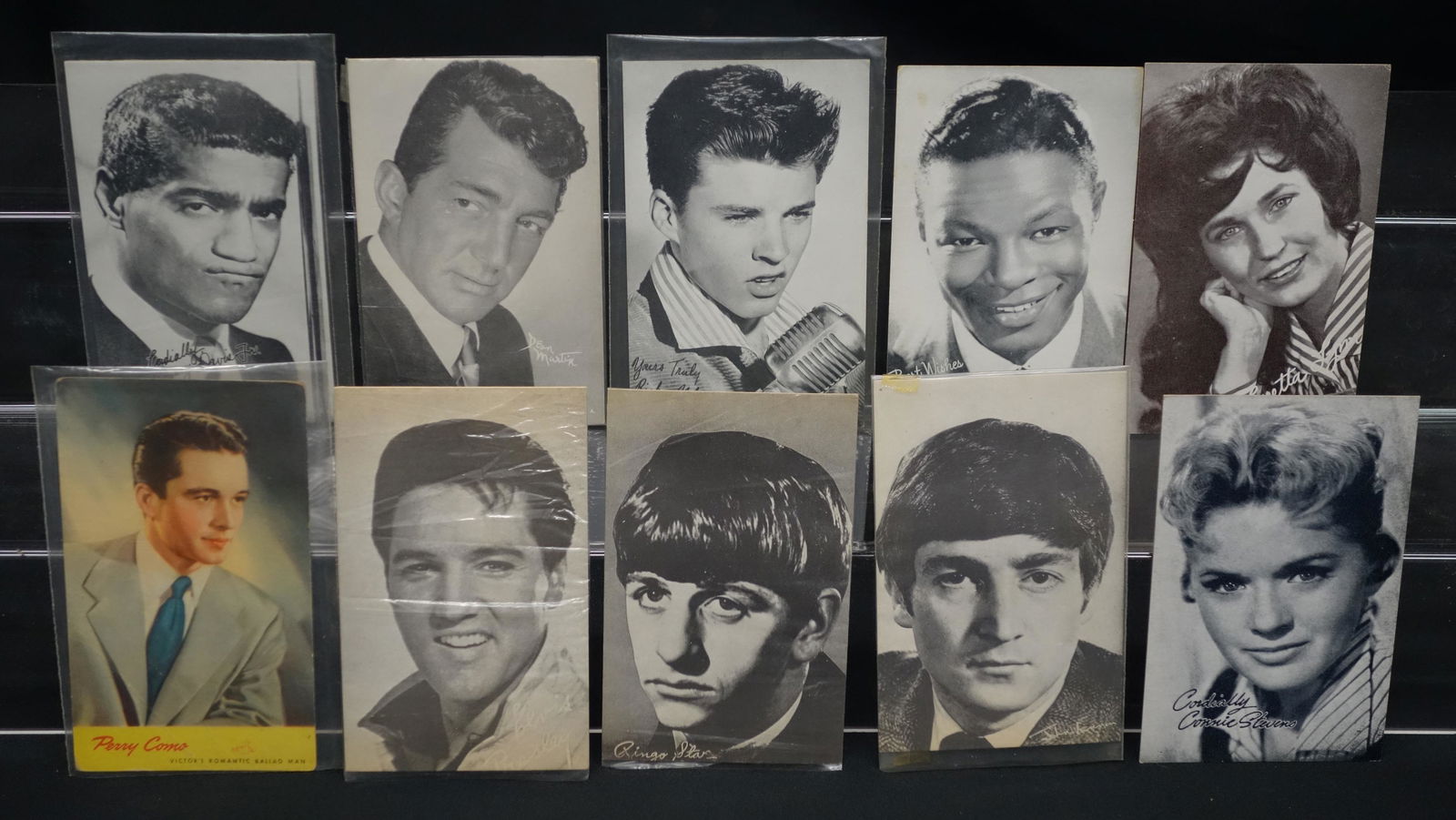 AMUSEMENT CELEBRITY CABINET CARDS (70+/-): Litho cardboard; Dean Martin, Nat King Cole, Ricky Nelson, Sammy Davis, Perry Como, Loretta Lynn, Ringo Starr, John Lennon, Elvis, Connie Stevens, Sarah Vaughan, etc.; normal wear; some fading; 5 1/2"