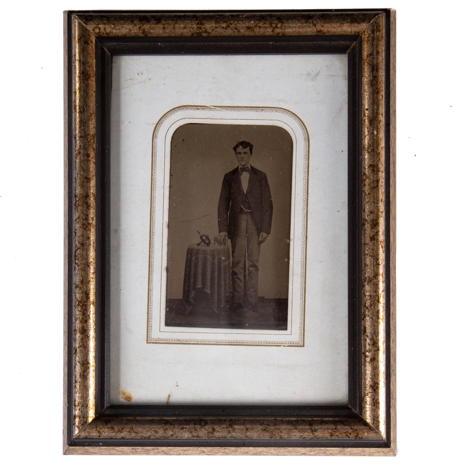 TINTYPE YOUNG MAN with STEREOPTICON: 6th plate; clear image of young man wearing watch chain standing next to table with hand-held stereopticon and stereopticon cards; matted in album mat and new wood frame
