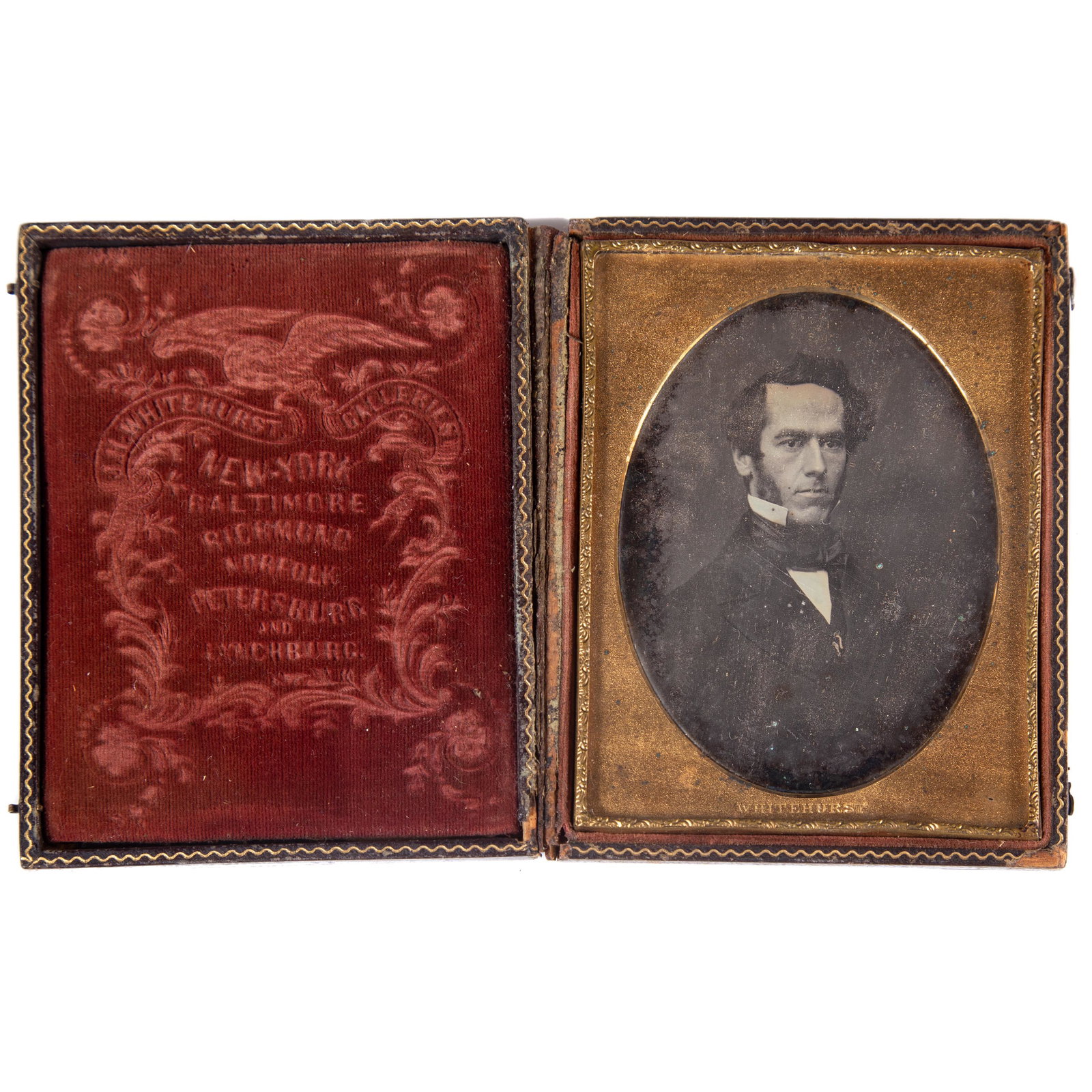 WINEHURST DAGUERREOTYPE PORTRAIT OF MAN: Quarter plate (?); image of young stately man with sideburns; Whitehurst stamped gilt mat; case has textured velvet "Whitehurst Galleries", addresses, eagle, etc.; pressed leather case worn; image sli