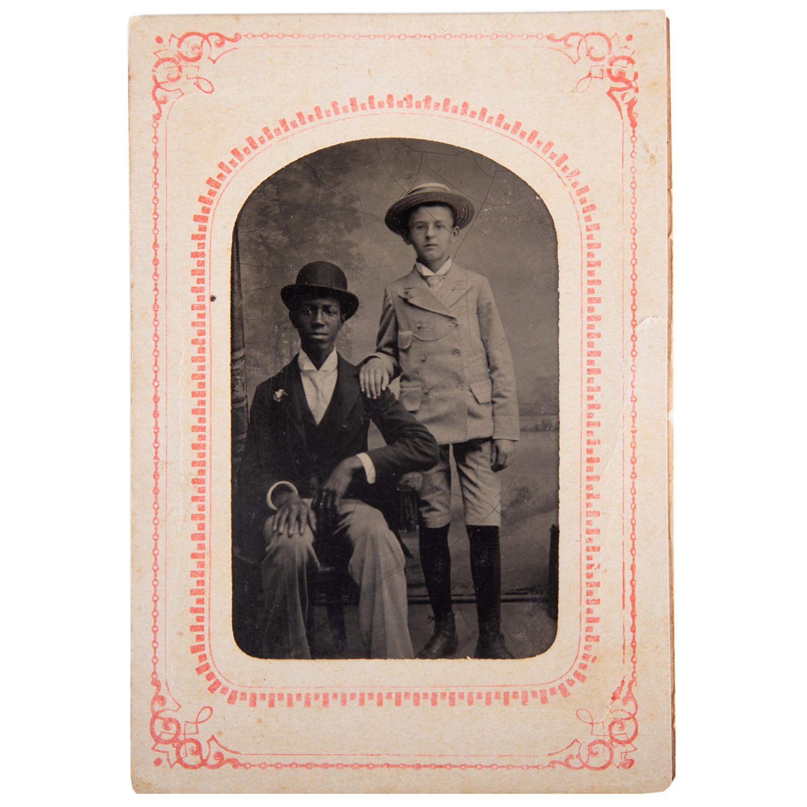 TINTYPE OF BLACK & WHITE YOUTHS: 6th plate; image of well dressed black young man wearing derby hat; young white male with bowler hat; paper litho mat, reverse: "Jacob Jones Photographer - Phila."; mat 4 1/2" x 3", G-VG